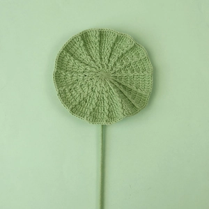 Detailed view of handmade crochet lotus leaf with delicate knitting texture and green stem