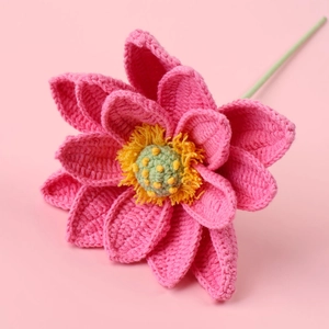 Macro detail of handmade crochet pink lotus flower with yellow stamens and green stem