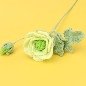 Detail of handcrafted crochet green rose with blooming head and realistic yarn leaves