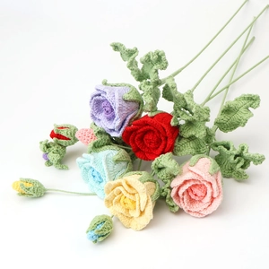 Close-up of handmade crochet rose bouquet with colorful flowers and green leaves