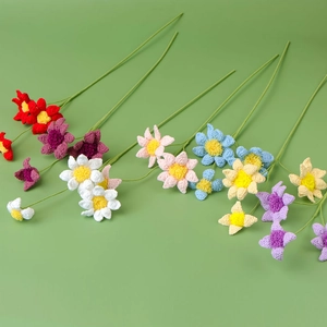 Detailed close-up of multi-colored handmade crochet daisy stems on a soft green backdrop