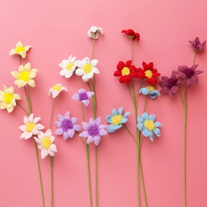 Handmade crochet flowers with colorful daisies and sunflowers on pink background