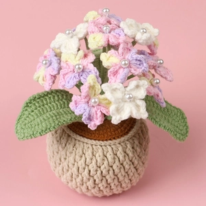 Detail of crochet hydrangea potted plant featuring colorful yarn flowers and pearl accents