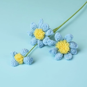 Close-up of handmade crochet blue daisies showing intricate yarn texture and yellow cores