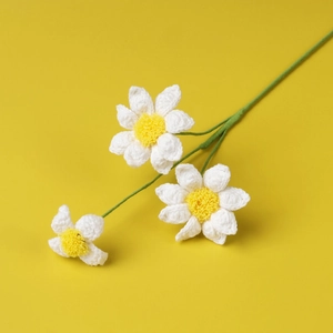 Detailed knit texture of handmade crochet daisy flowers with white petals and yellow centers