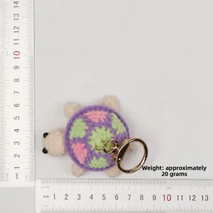 Macro shot showing size measurement of handmade crochet purple turtle keychain 6cm