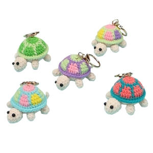 Five handmade crochet turtle keychains in various colors with gold spring clasps