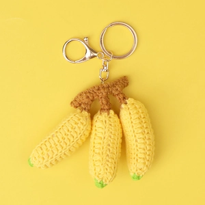 Detailed crochet banana keychain with three yellow fruits and golden metal lobster clasp