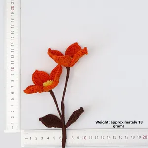 Detail shot of a handmade orange crochet flower with a ruler showing the 16.5cm height