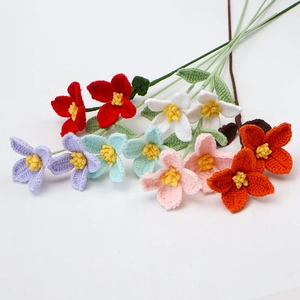 Detail of ten handmade crochet flowers in various colors with green stems and leaves