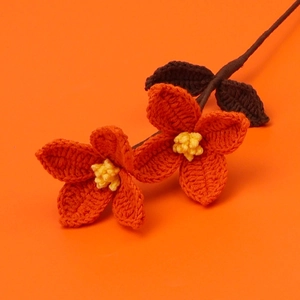 Detailed crochet orange flower bouquet with yellow center and dark brown leaves