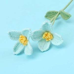 Detailed view of handmade sky blue crochet flowers with intricate knitted yarn textures