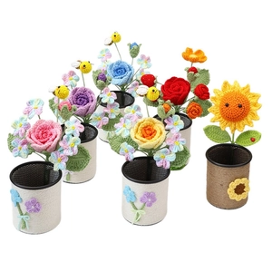 Handmade crochet flower pen holders with colorful roses and sunflowers on white background