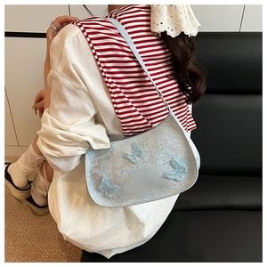 Détail du sac à bandoulière en dentelle bleu clair avec papillons 3D et design élégant