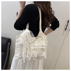 Detailed view of cream lace tote bag featuring triple layers of ruffles and a large bow