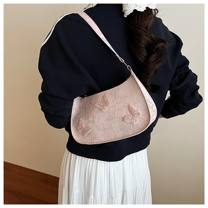 Borsa a spalla in pizzo rosa con ricamo a farfalla 3D indossata da una modella