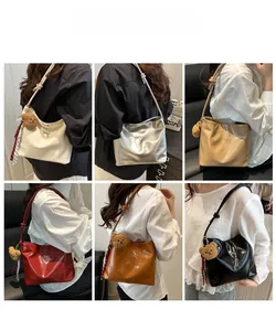 Detailansicht des eleganten Beutelgurt-Designs mit Plüschbären-Anhänger und Band