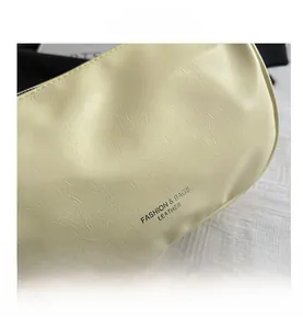 Close-up of beige cracked leather texture with printed fashion lettering on shoulder bag