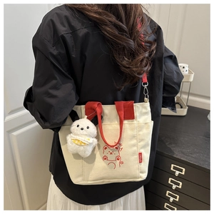 Detail showing back view of casual canvas tote with red straps and cute dog charm