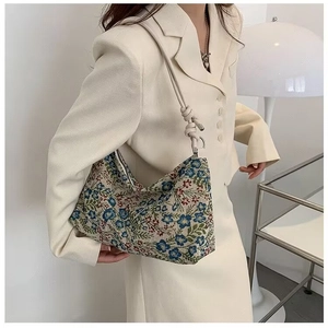 Close-up of ethnic style floral jacquard shoulder bag with decorative knotted strap details