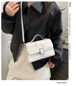Vue détaillée du sac bandoulière en cuir blanc avec boucle argentée porté par un mannequin