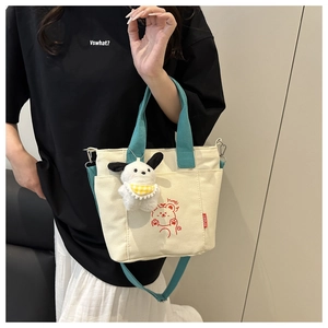 Canvas crossbody bag with green straps and cute bear print worn by a model