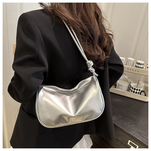 Zilveren metallic halve maan tas met knoopdetail getoond op een vrouwelijk model
