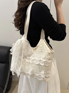 Lace tote bag with large bow detail and layered ruffles for elegant vacation style