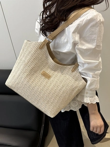Large hand-woven straw tote bag with brown leather straps for beach and daily commute