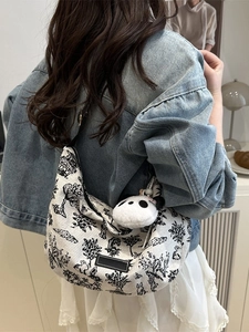 Ink landscape canvas shoulder bag with panda charm shown on model in summer outdoors