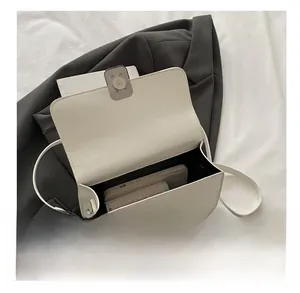 Vue intérieure d'un petit sac bandoulière crème montrant la capacité pour le téléphone