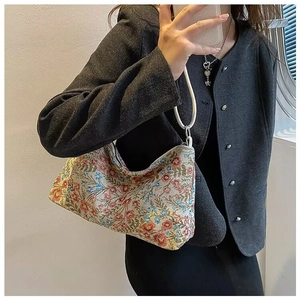 Close-up of ethnic floral jacquard handbag with circular handle and zipper closure