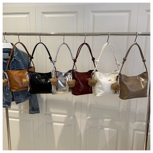 Detail view of colorful bucket bags with cute bear charms and trendy knotted shoulder straps
