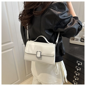 Détail d'un sac bandoulière blanc vintage avec boucle argentée et poignée élégante