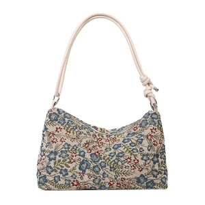 Detail of floral jacquard fabric and beige leather strap with knot on shoulder bag