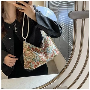 Detail of floral embroidery on canvas shoulder bag with woven white rope handle