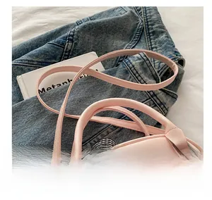 Pink PU leather handbag detail with comfortable shoulder strap and plaid ribbon bow