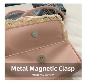 Detail of pink faux leather bag featuring a magnetic hardware snap and crochet lace trim