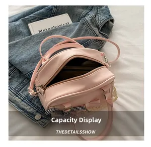 Spacious interior of light pink faux leather bag with lace bow showing large capacity