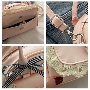 Detail of pink PU leather handbag with white lace trim and checkered bow accent