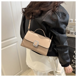 Close-up of a vintage beige square handbag with a silver metal clasp and a slim strap