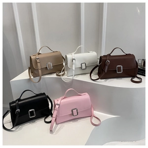 Cinq sacs à rabat tendance en différentes couleurs sur des marches blanches