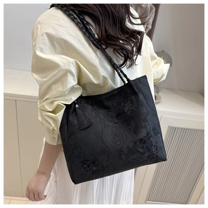 Detail of black jacquard tote bag with butterfly embroidery and woven shoulder strap