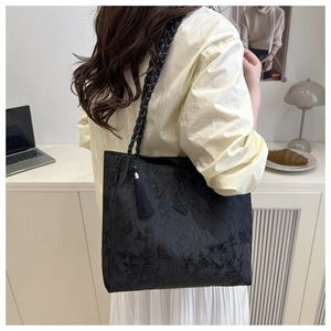 Detail of black jacquard tote bag with butterfly patterns and woven handle straps