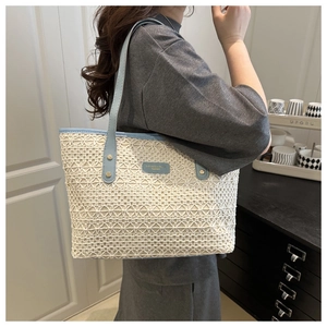 Detail of summer straw shoulder bag with light blue leather trim and metal rivets