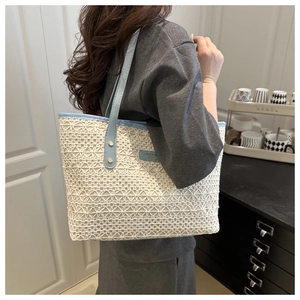 Detailed shot of large capacity white crochet tote bag with light blue leather straps