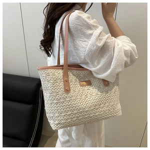 Detail of woven lace tote bag with pink leather handle and gold Cameo fashion logo