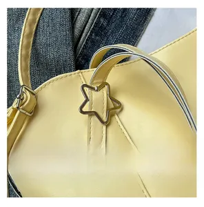 Detail of yellow soft leather tote featuring a silver star buckle and fine stitching