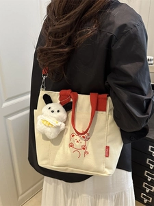 Canvas crossbody bag with red handles and cute bear graphic on beige fabric