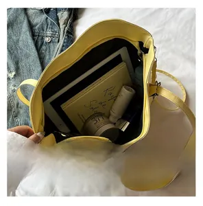 Macro view of spacious yellow faux leather tote bag interior with multiple items